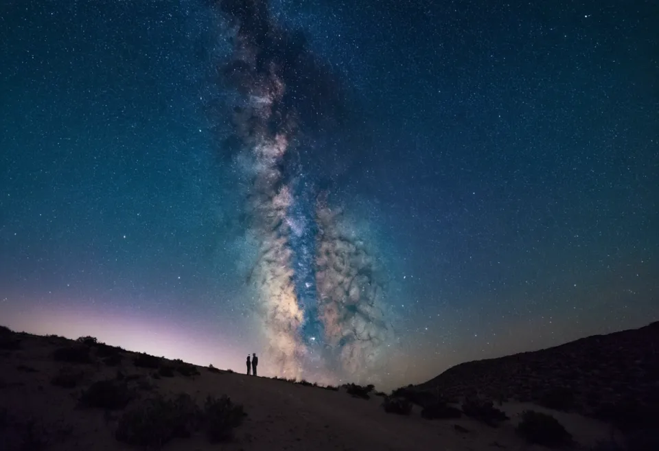 L'arche de la Voie lactée au-dessus d'un horizon sombre